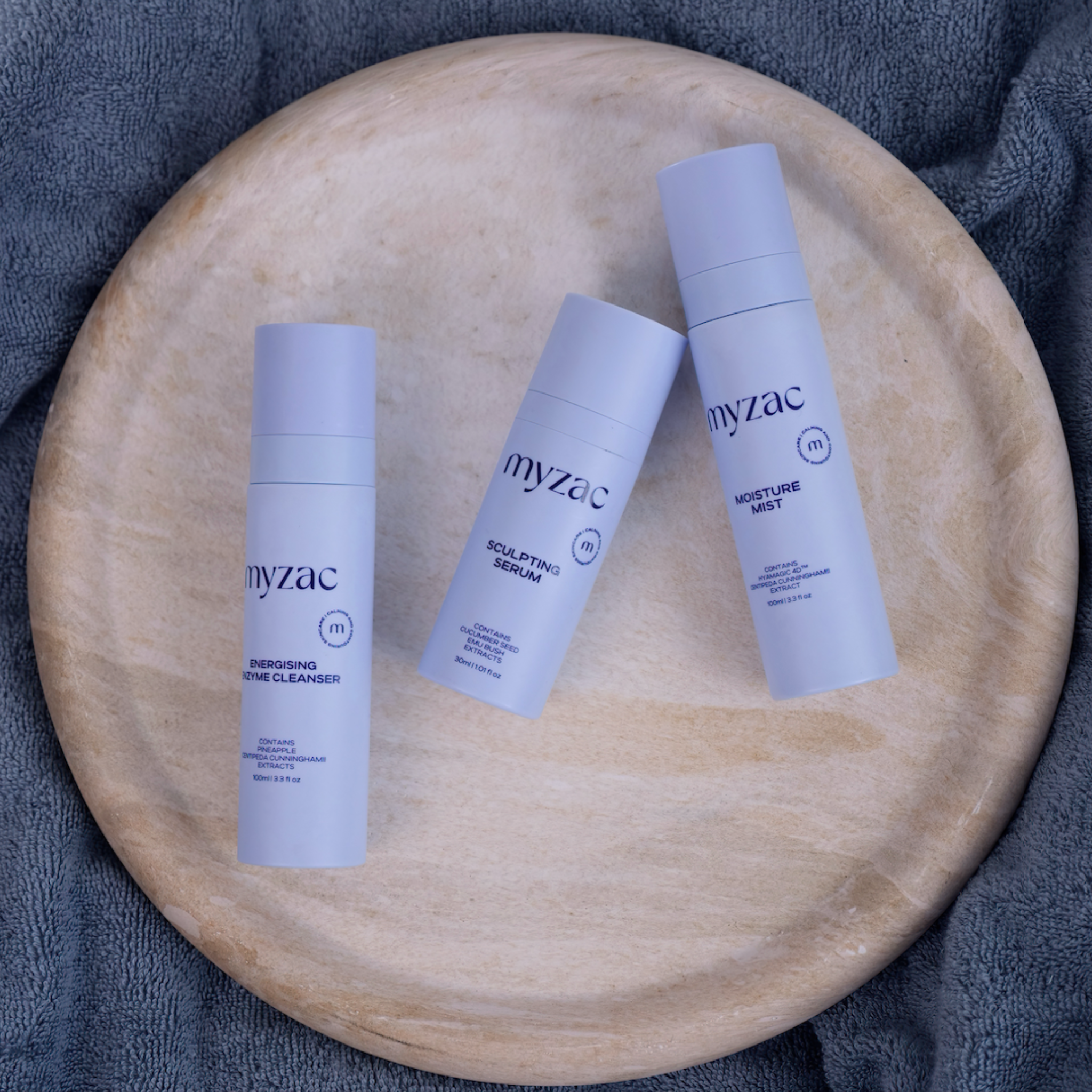 Flat lay of the Full Ritual Bundle featuring Energising Enzyme Cleanser, Sculpting Serum, and Moisture Mist on a marble tray.