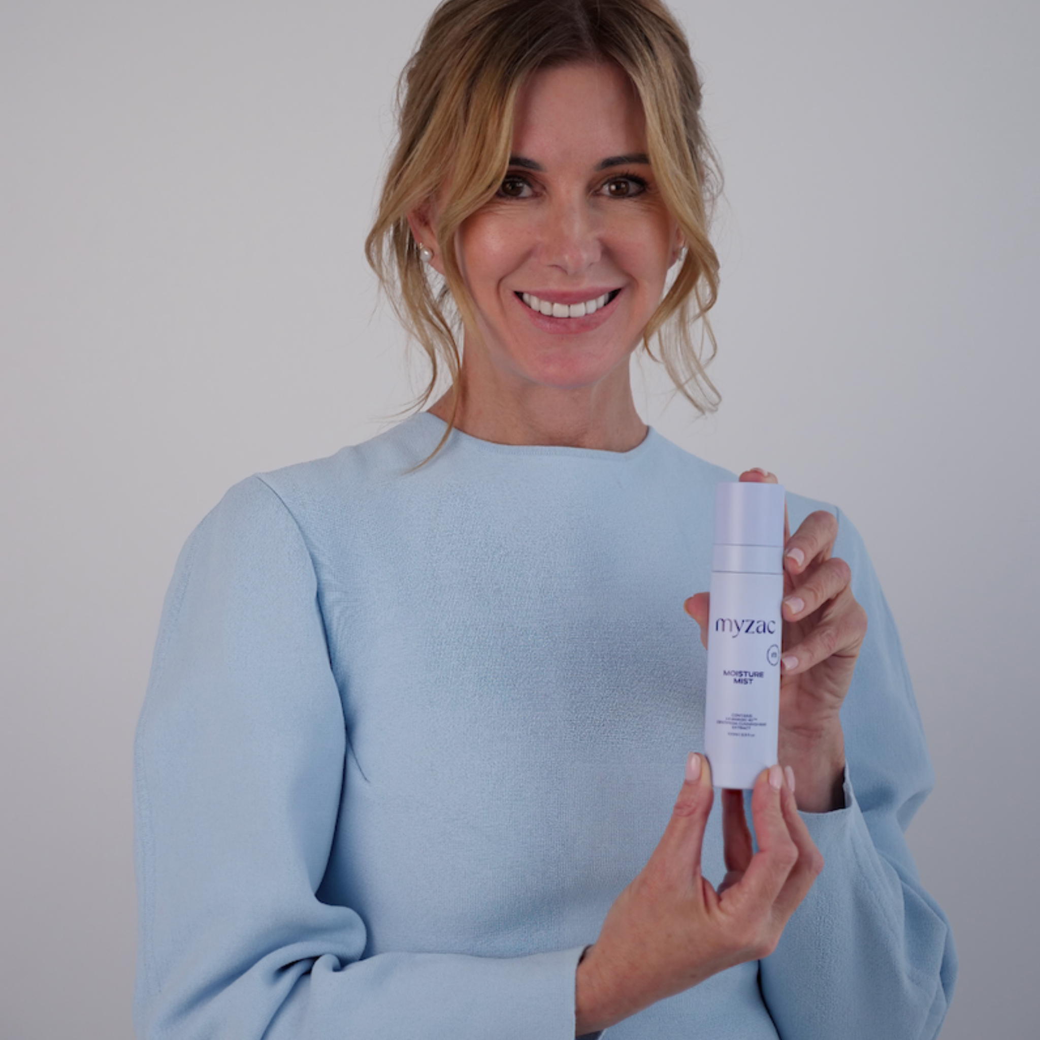 Model holding MYZAC Moisture Mist bottle.