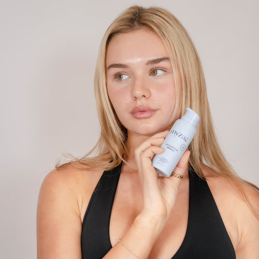Model applying myzac Sculpting Serum around the eye area