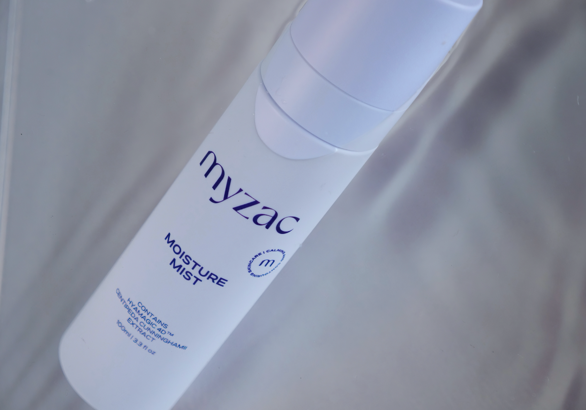 MYZAC Moisture Mist bottle displayed on a light reflective surface, highlighting its hydrating and refreshing skincare benefits.